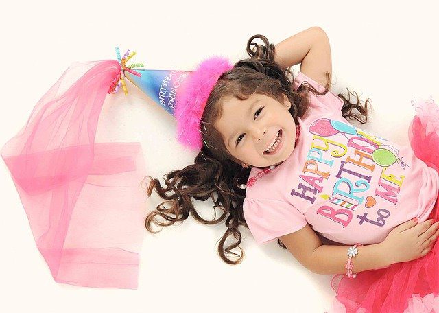 niña con sombrero de colores, cellebrando cumpleaños